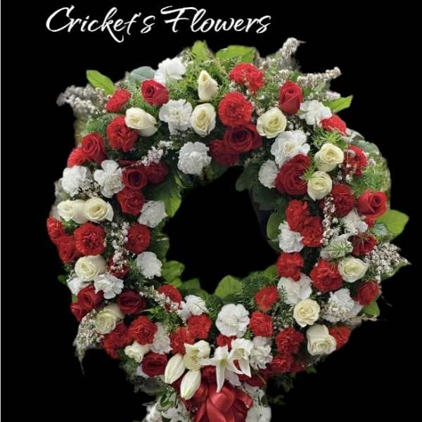 Large red and white floral wreath with a cascading ribbon tail