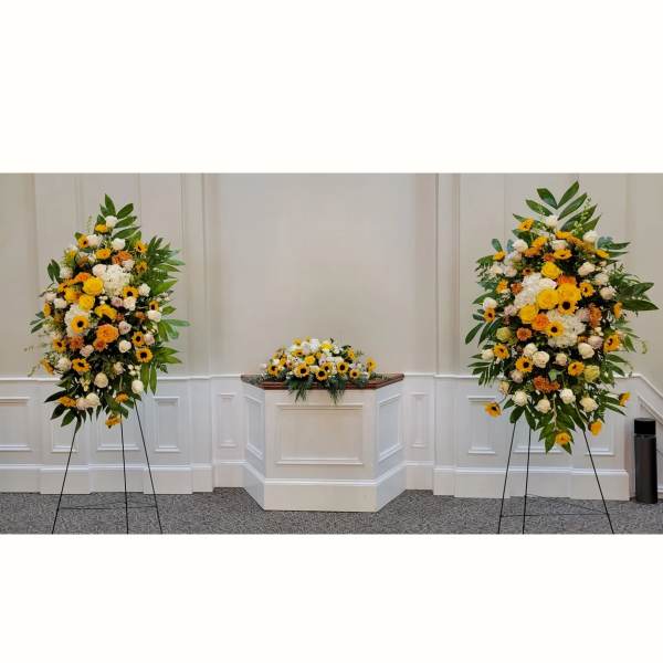 Set of yellow and white standing sprays with matching altar arrangement in a chapel setting