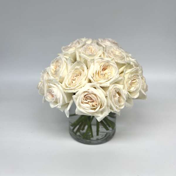Cream rose bouquet in a clear glass vase