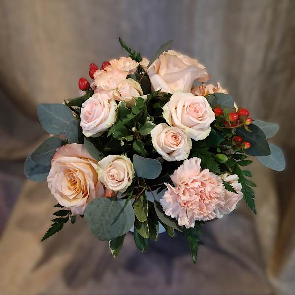 Bouquet of pale pink roses and carnations with red berries
