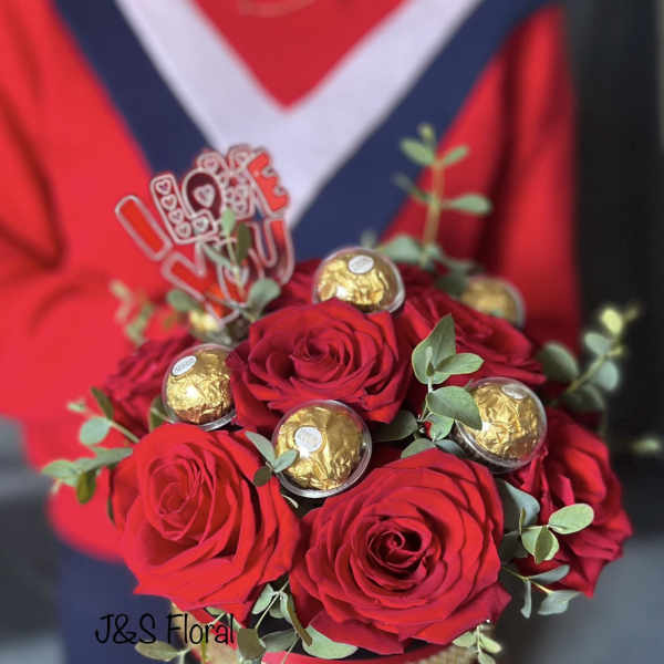 Red roses arranged with gold-wrapped chocolates and a "Love You" topper