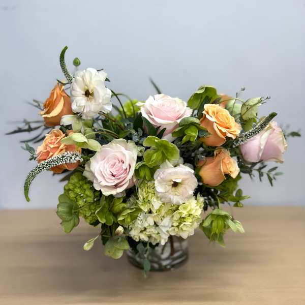 Bouquet of pale roses and white blooms in a glass vase