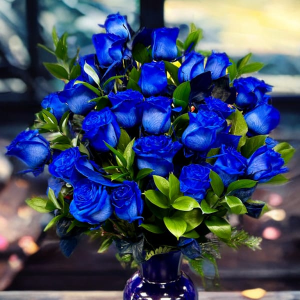 Blue roses arranged in a purple glass vase