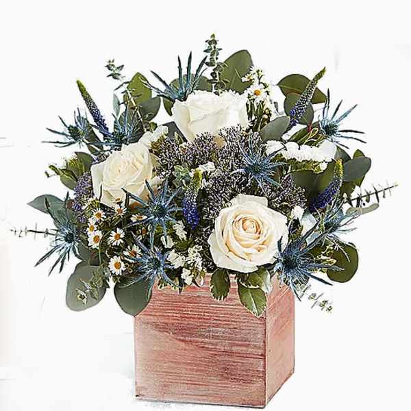 White roses and blue thistle in a pink wooden box