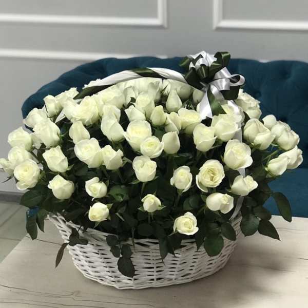 White rose bouquet in a white wicker basket with a ribbon bow