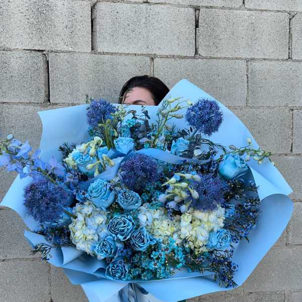 Large blue bouquet with roses, hydrangeas, and round allium blooms