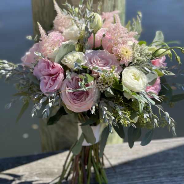 Pink and white bouquet of roses and ranunculus with greenery