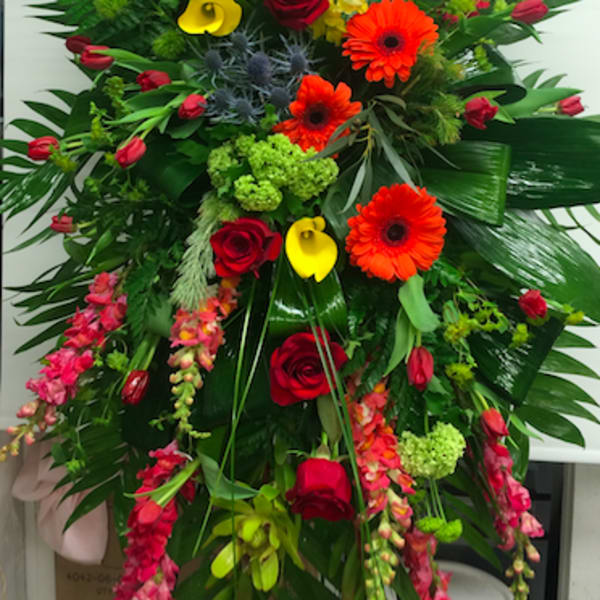 Tall mixed floral arrangement with red roses, orange gerberas, and yellow calla lilies