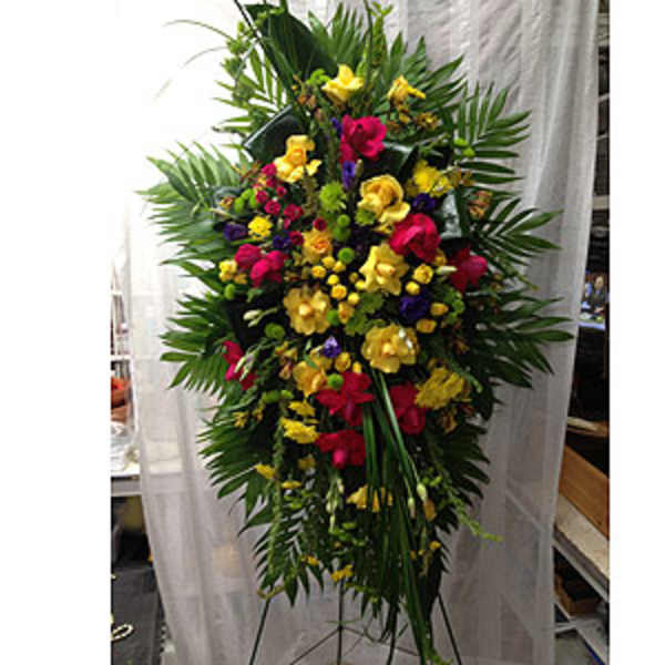 Tall standing floral spray with yellow, pink, and purple flowers