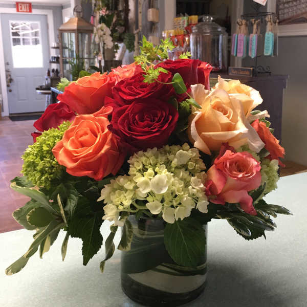 Mixed roses and hydrangeas arranged in a glass vase