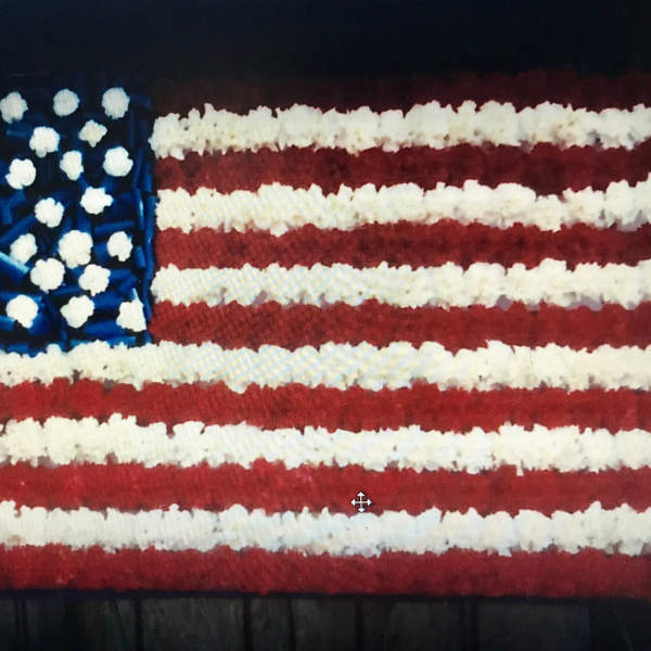 Floral arrangement shaped like the American flag in red, white, and blue