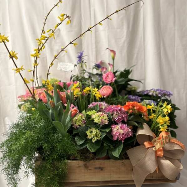 Mixed floral arrangement in a wooden crate with a burlap bow