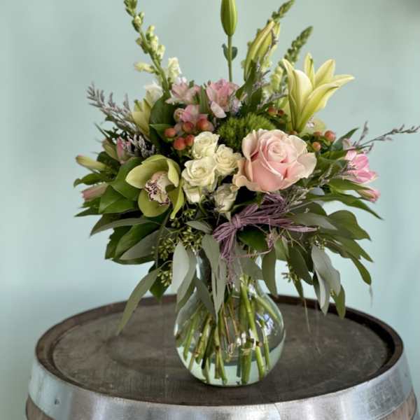 Mixed bouquet of pink and white flowers in a clear glass vase