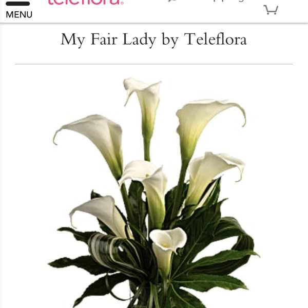 White calla lilies arranged in a clear glass vase