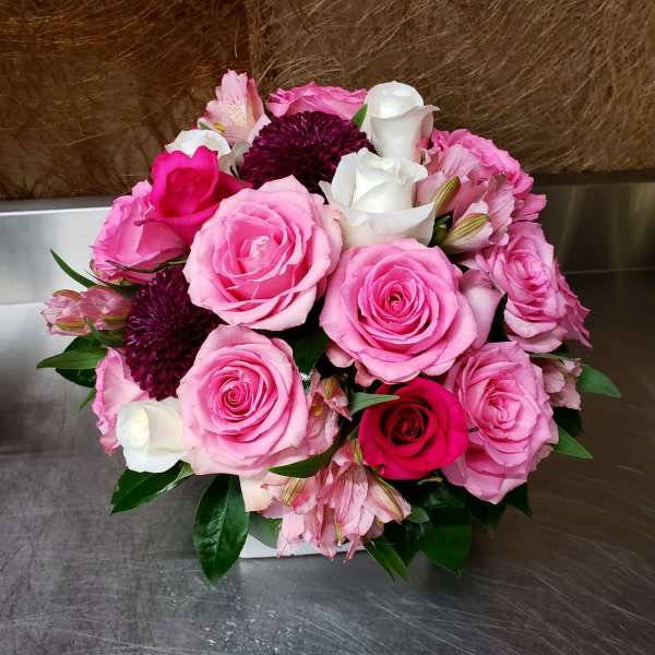 Bouquet of pink and white roses with dark purple blooms