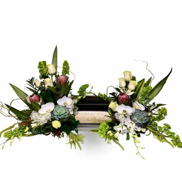 Symmetrical floral arrangement with orchids, roses, and succulents around a casket