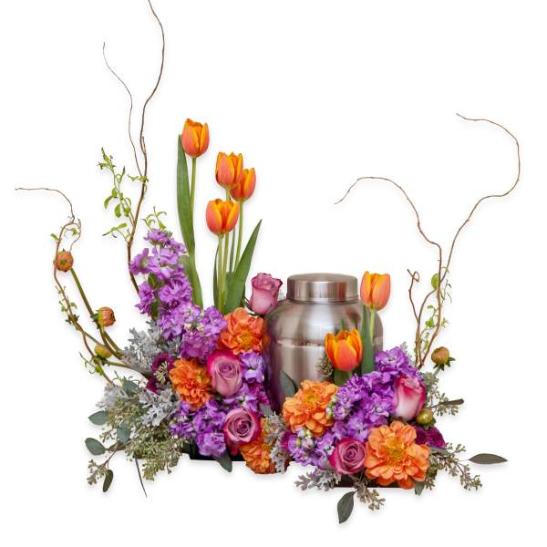 Orange tulips and purple flowers arranged around a silver urn
