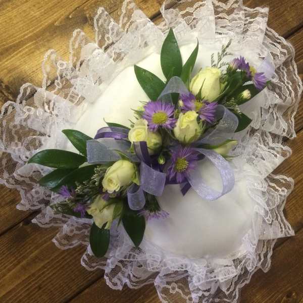 White lace ring pillow with purple and cream floral spray