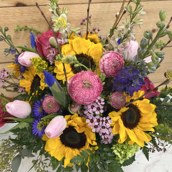 Mixed bouquet with sunflowers, pink tulips, and purple blooms