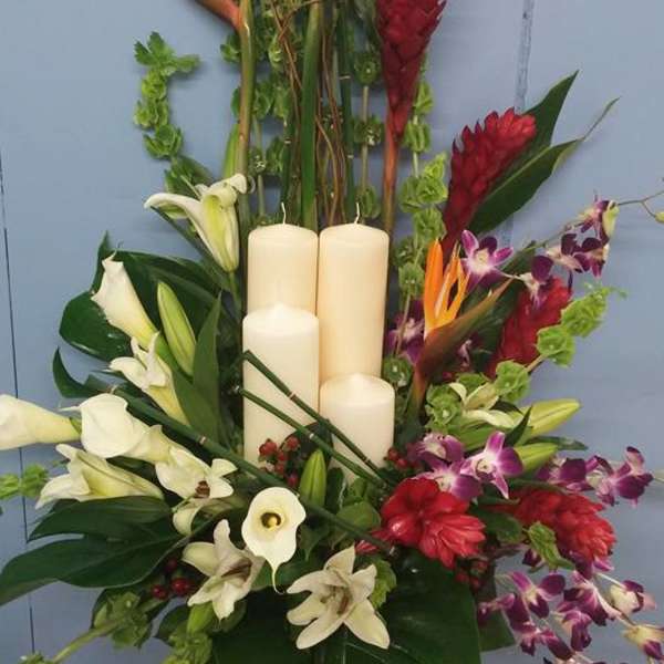 Tropical floral arrangement with white lilies, orchids, and candles