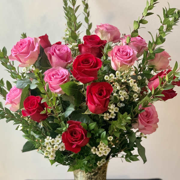 Pink and red roses arranged in a gold vase