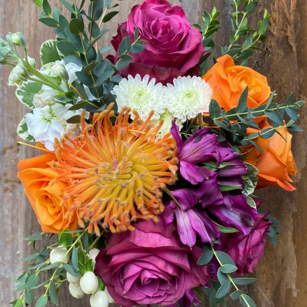 Bouquet of orange, magenta, and white flowers with eucalyptus foliage