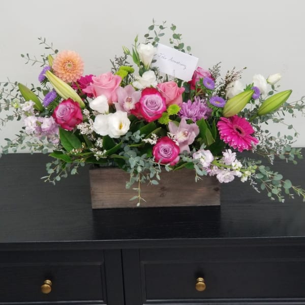 Mixed pink and white flower arrangement in a wooden box