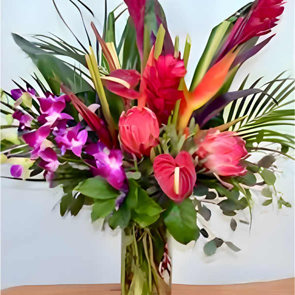 Tropical bouquet with pink orchids and red bird-of-paradise in a glass vase