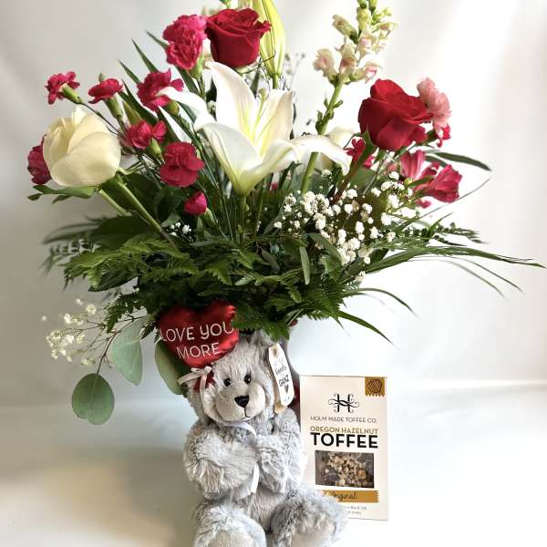 Bouquet with red and white flowers in a teddy bear gift arrangement