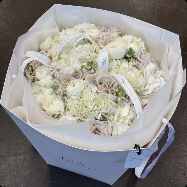 Bouquet of white and blush flowers wrapped in white paper