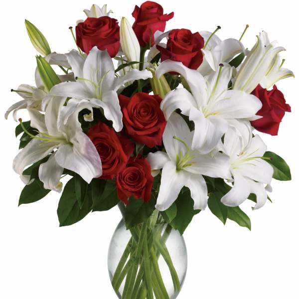 Red roses and white lilies arranged in a clear glass vase