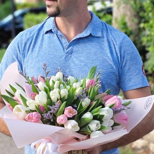 Bouquet of pink and white tulips wrapped in pale pink paper