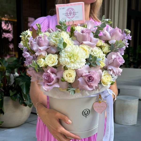 Lavender and cream bouquet in a round hatbox with ribbon