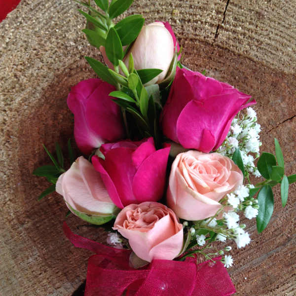 Small bouquet of pink and blush roses with a magenta ribbon