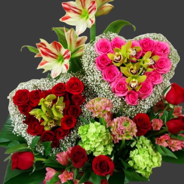 Heart-shaped bouquet of red and pink roses with white orchids and lilies