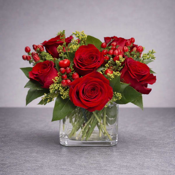 Red roses arranged in a clear glass vase