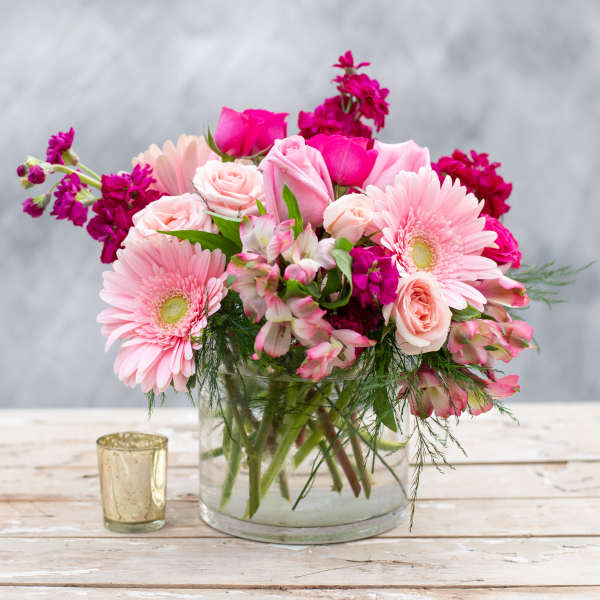 Pink bouquet of roses and gerbera daisies in a glass vase