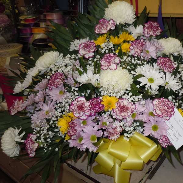 Large mixed flower spray with a yellow ribbon bow