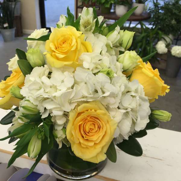 Yellow roses and white hydrangeas in a glass vase