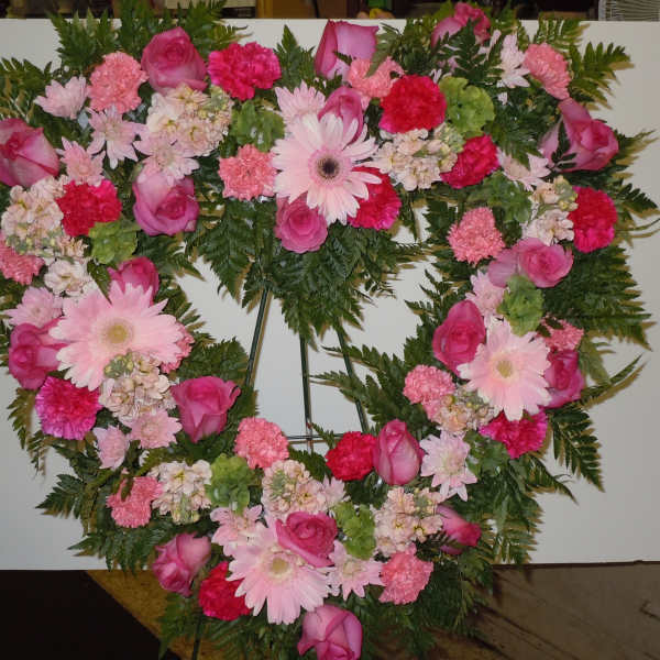 Heart-shaped floral wreath with pink roses and daisies