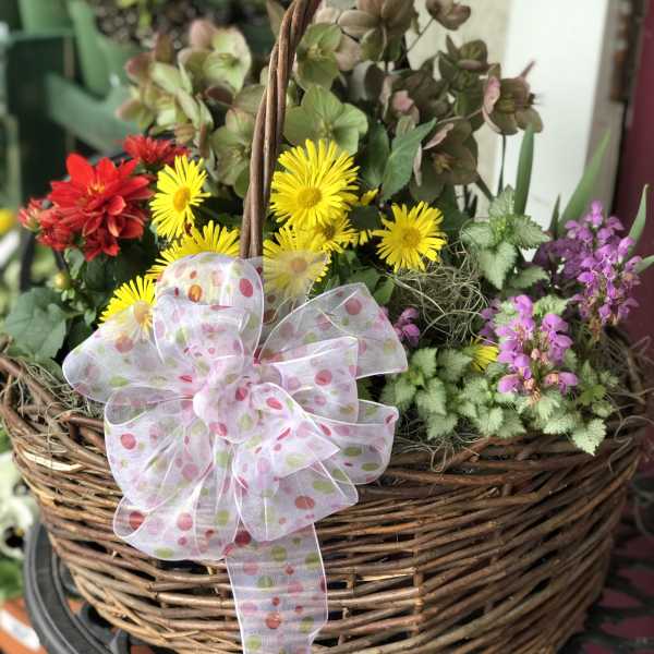 Basket of yellow and red flowers with a polka-dot ribbon bow