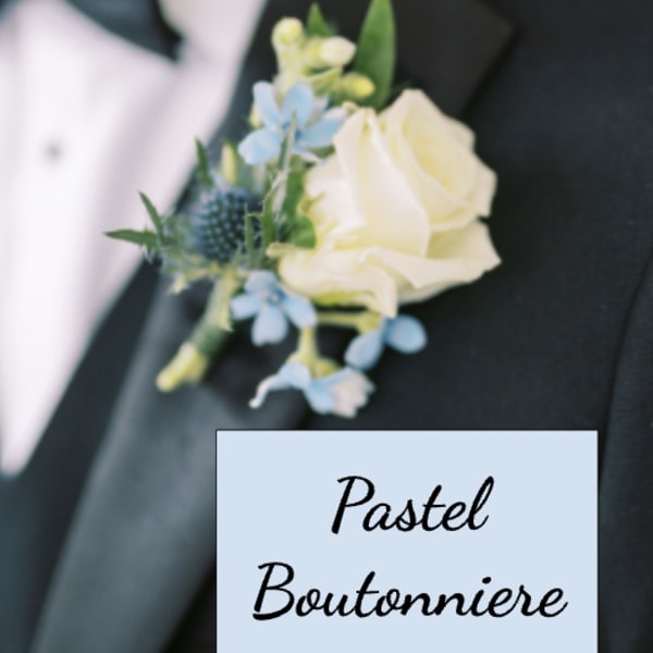 Pastel boutonniere with white rose and small blue flowers pinned to a black tuxedo lapel