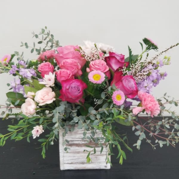 Pink and lavender rose bouquet in a white wooden box