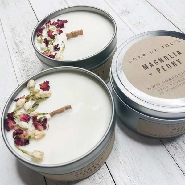 Three round tin candles with dried flower petals on top