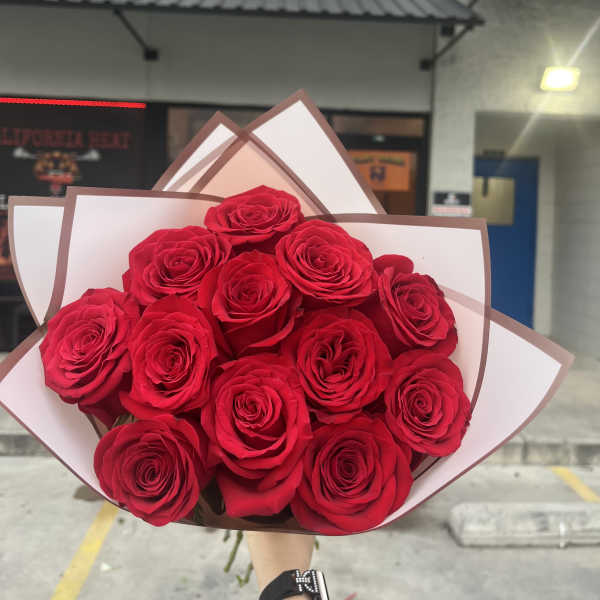 Bouquet of red roses wrapped in white and brown paper