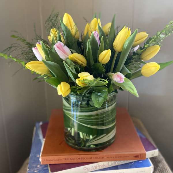 Yellow and pink tulips arranged in a glass vase