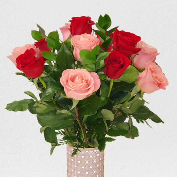 Bouquet of red and pink roses in a tall glass vase