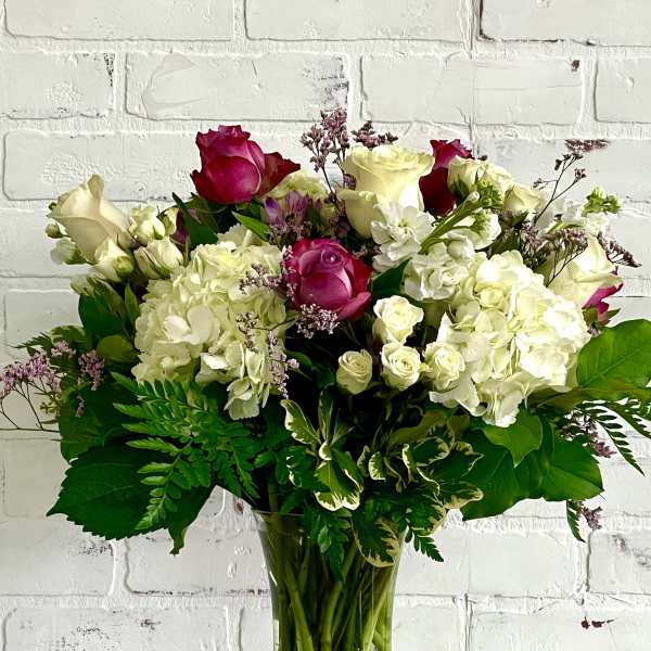 Bouquet of pink and white roses with hydrangeas in a glass vase
