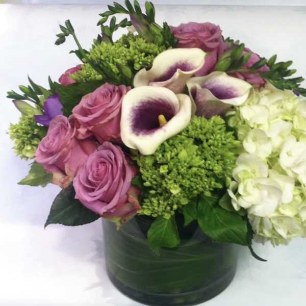 Pink roses and white calla lilies in a green vase