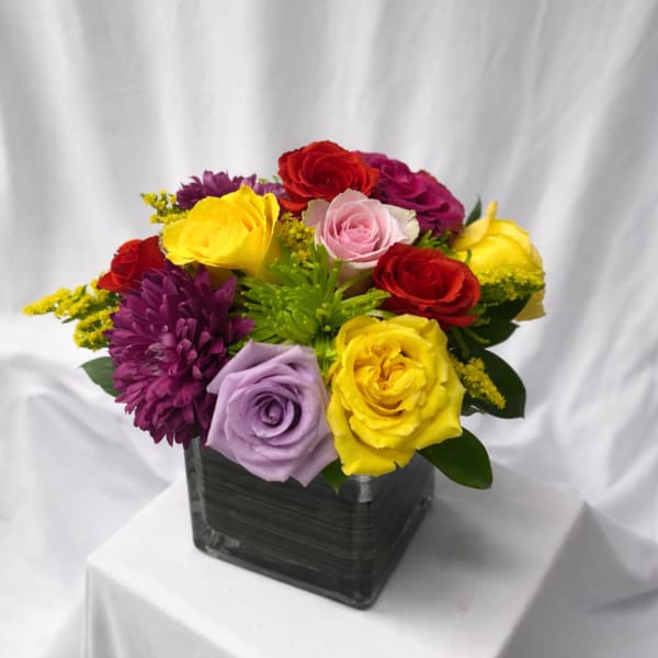 Colorful rose bouquet in a square glass vase
